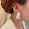Close-up of a model wearing smooth white C-shaped geometric earrings in a minimalist style - White Acrylic C-Shape Style