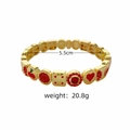 Gros plan d'un bracelet extensible doré avec breloques en émail cerise et cœur, 20,8 g - Cœur Cerise Rouge
