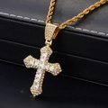 Vue détaillée du pendentif croix dorée serti de zircons avec chaîne torsadée hip-hop - Collier Croix Iced Out Or
