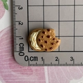 Makroaufnahme von Miniatur-Resin-Schokokeks mit Bissspuren und 2 cm Größenvergleich - Schokoladenkeks