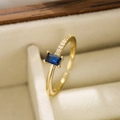 Gros plan détaillé d'une bague ajustable dorée avec pierre bleue dans un écrin à bijoux - Ouvert Réglable / Bleu foncé