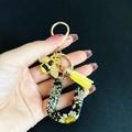 Detail of letter U keychain with real dried daisies, resin gold foil, and bee charm - Letter U