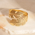 Nahaufnahme des goldenen Blatt-Armreifs mit feiner Pflanzenstruktur auf Steinhintergrund - Blatt (Gold) / Gold