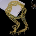 Macro detail of a sparkling gold mesh beaded scarf necklace accented with blue crystals - Gold-Blue