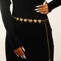 Close-up of golden heart-shaped metal belt with embossed texture on black dress - Heart Embossed Style (M-231)