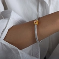Silver twisted cable wire bracelet featuring a gold cylinder with a pink marquise gemstone - Orange Zirconia