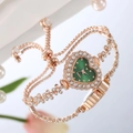 Détail de la montre cœur en or rose avec cadran émeraude et bracelet fleuri serti - Vert