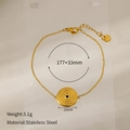 Dettaglio di un bracciale in acciaio inossidabile dorato con ciondolo a trama concentrica - Pietra Verde Tonda Oro