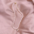 Baroque freshwater pearl necklace featuring a gold deer pendant on pink silk background - Deer - Cat Eye