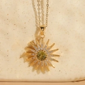 Collana girasole d'oro con ciondolo in zircone verde oliva su ceramica beige - verde oliva