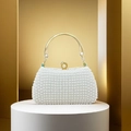 Detail einer luxuriösen Perlen-Abendtasche mit goldenem Griff und edlem Verschluss - Weiß