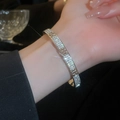 Close-up of silver bangle featuring sparkling zircon stones and a classic H letter clasp - Silver Letter