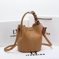 Light brown leather bucket bag with decorative polka dot scarf handle and crossbody strap - Durable Brown