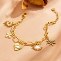 Dettaglio del braccialetto occhio del diavolo dorato con ciondoli farfalla e cuore - Braccialetto Evil Eye Oro