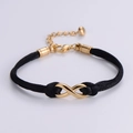 Detail of minimalist infinity symbol bracelet with golden hardware and black woven cord - Gold (Black Rope)