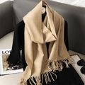 Detail van licht camel cashmere-gevoel sjaal met franjes in een stijlvolle lifestyle setting - Beige
