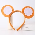 Detailed view of plush orange animal ears headband on minimalist display props - Monkey