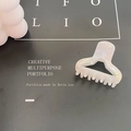 Mini iridescent pearly white triangular claw clip with hollow design on black background - White Enamel