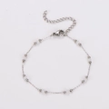 Primer plano de pulsera de cadena plateada con pequeñas cuentas blancas y cierre de langosta - Pulsera / Color Acero