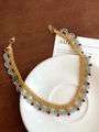 Détail du collier de perles fait main avec perles bleues et dorées sur assiette blanche - Style Tissé en Vague d'Éventail (Collier 1#) / Or-Bleu-Rouge