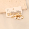 Détail macro du lot de boucles d'oreilles en acier doré avec perles blanches et cœurs - Style 7 Cœur