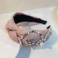 Detail eines rosa Knotenstirnbandes mit Silbernieten und weißem Perlenakzent - Metallic-Korean-Rosa