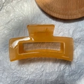 Detail of a large rectangular amber hair claw clip with a strong metal spring - Jelly Yellow