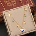 Detail der Goldkette mit Hamsa-Hand und Evil-Eye-Anhängern auf Schmuckkästchen - Böser Blick Krone Hamsa Hand Stil