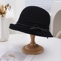Close-up of black breathable woven sun hat featuring a leather band and bow on a wooden stand - Black