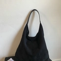 Grand sac cabas minimaliste en daim noir avec bandoulière assortie sur mur blanc - Avec sac intérieur / Noir
