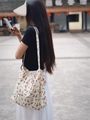 Minimalist canvas tote bag with colorful dog prints shown on a model in an outdoor setting - Full Color Dog Print (Cream White)
