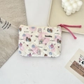 Close-up of quilted floral cosmetic bag with cute puppy print and pink woven zipper pull - Puppy Paradise