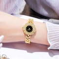 Close-up of golden flower-shaped quartz watch with diamond-encrusted bracelet and dial - Gold Band Gold Case Black Dial