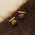 Nahaufnahme von Tigerauge-Ohrsteckern auf braunem Plüsch mit goldener Hochglanzpolitur - Goldenes Tigerauge
