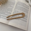 Elegante forcina beige a forma di U in resina su un libro aperto per lo styling quotidiano - Cachi