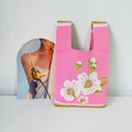 Détail du sac fourre-tout en tricot rose avec motif floral et anses vertes - Fleur de Cerisier Rose