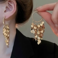 Detail of gold C-shaped hoop earrings featuring shimmering tiered heart tassel drops - Gold Heart Tassel