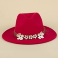 Détail d'un chapeau fedora rouge avec ruban en cuir marron et fleurs blanches rivetés - M (56-58cm) / Rouge