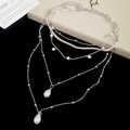 Macro-opname van zilverkleurige gelaagde ketting met waterdruppelparels en slangenketting - Zilver