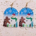 Gros plan de boucles d'oreilles de Noël en acrylique avec motifs bonhomme de neige et flocons - Thème d'Hiver Bleu Clair