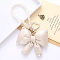 Detail of champagne satin bow keychain with pearl chain and silver heart clasp - Off-white