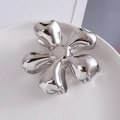 Dettaglio di una molletta per capelli a fiore in metallo argento su un piatto di ceramica - Grande / 2# Argento Grande 8cm