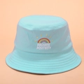 Zoom sur la broderie arc-en-ciel et le texte Radiate Positivity sur bob en coton bleu ciel - Taille unique / Bleu Ciel