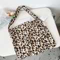 Detailed view of beige leopard print canvas tote bag with side label on white surface - Large Patch Beige