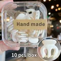 Detalle de set de 10 pinzas de pelo mini blanco mate en caja de regalo transparente - 10 Unidades/Caja / Blanco Roto