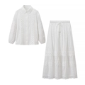 Detail van wit opengewerkt borduursel op tweedelige set met kantblouse en lange rok - S / Wit