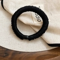 Detalle de un coletero negro grueso fruncido con una hebilla cilíndrica negra brillante - Negro