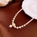 Macro shot of pearl necklace with square zircon pendant on elegant silk fabric - Champagne Gemstone Square Pendant / Gold-White