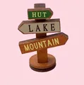 Miniature wooden signpost figurine with directional arrows for hut, lake, and mountain - Wooden Road Sign