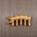 Macro detail of natural sandalwood massage comb with smooth five-tooth meridian design - Golden Sandalwood Caterpillar Shape (11.5*5.5*1.8cm)
